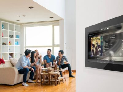 a group of friends in a living room with a smart tv on the wall